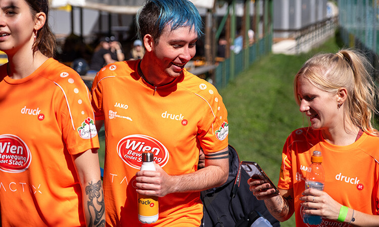 Spieler:innen gehen mit Trinkflaschen in den Händen vom Fußballplatz Spieler:innen gehen mit Trinkflaschen in den Händen vom Fußballplatz