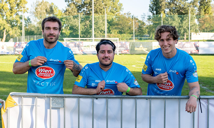 Drei Spieler zeigen stolz ihr Trikot in die Kamera Drei Spieler zeigen stolz ihr Trikot in die Kamera