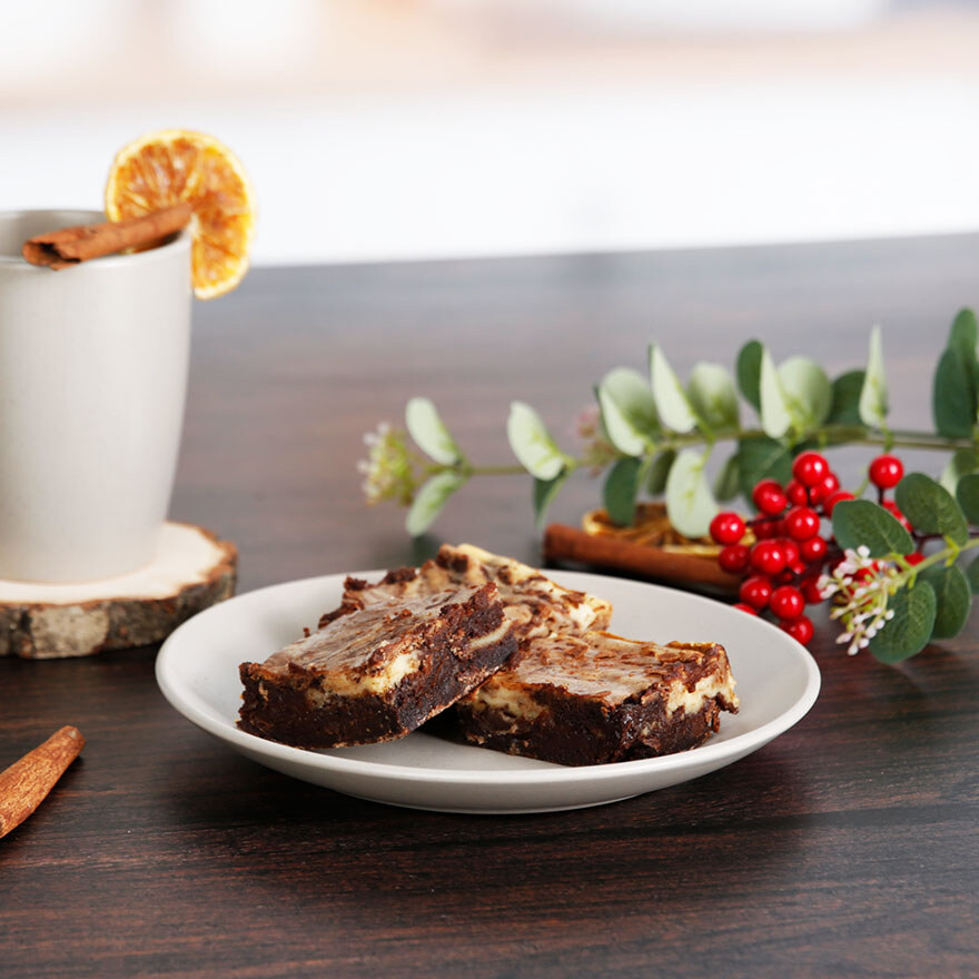 Auf dem Tisch steht ein Teller mit Gingerbread Brownies und Weihnachtdeko