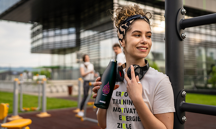Eine junge Frau trägt Sportgewand und steht auf einem Sportplatz Eine junge Frau trägt Sportgewand und steht auf einem Sportplatz