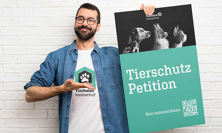 Mann hält ein Plakat zu einer Tierschutz Petition