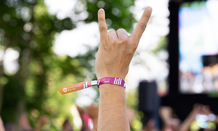 Mann trägt ein Einlassbändchen eines Festivals Mann trägt ein Einlassbändchen eines Festivals