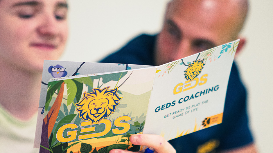 Kind und Betreuer schauen in ein Booklet Kind und Betreuer schauen in ein Booklet