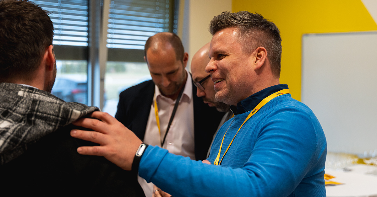 Eine Mann hält seine Hand auf der Schulter eines anderen, während sie reden Eine Mann hält seine Hand auf der Schulter eines anderen, während sie reden