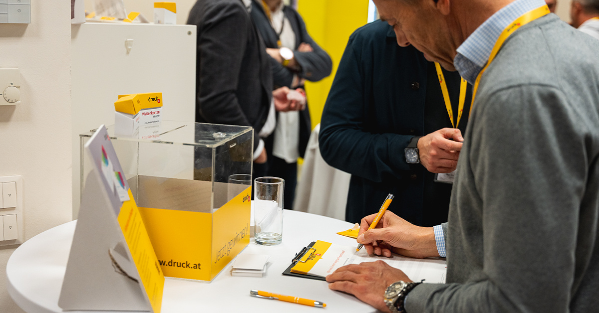 Eine Person füllt an einem Stehtisch einen Zettel aus Eine Person füllt an einem Stehtisch einen Zettel aus