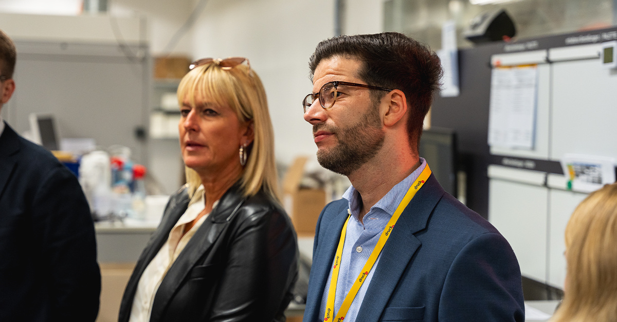 Personen hören während der Produktionsführung zu Personen hören während der Produktionsführung zu