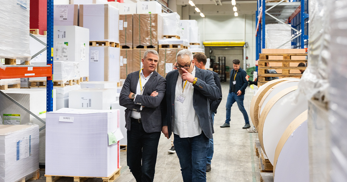 Zwei Männer gehen durch die Produktionshalle Zwei Männer gehen durch die Produktionshalle